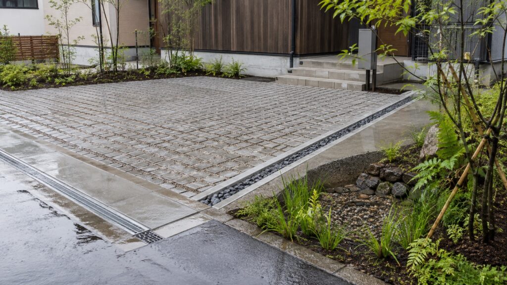 住宅の駐車場で透水性舗装と雨水の流れを確認するテーマ画像